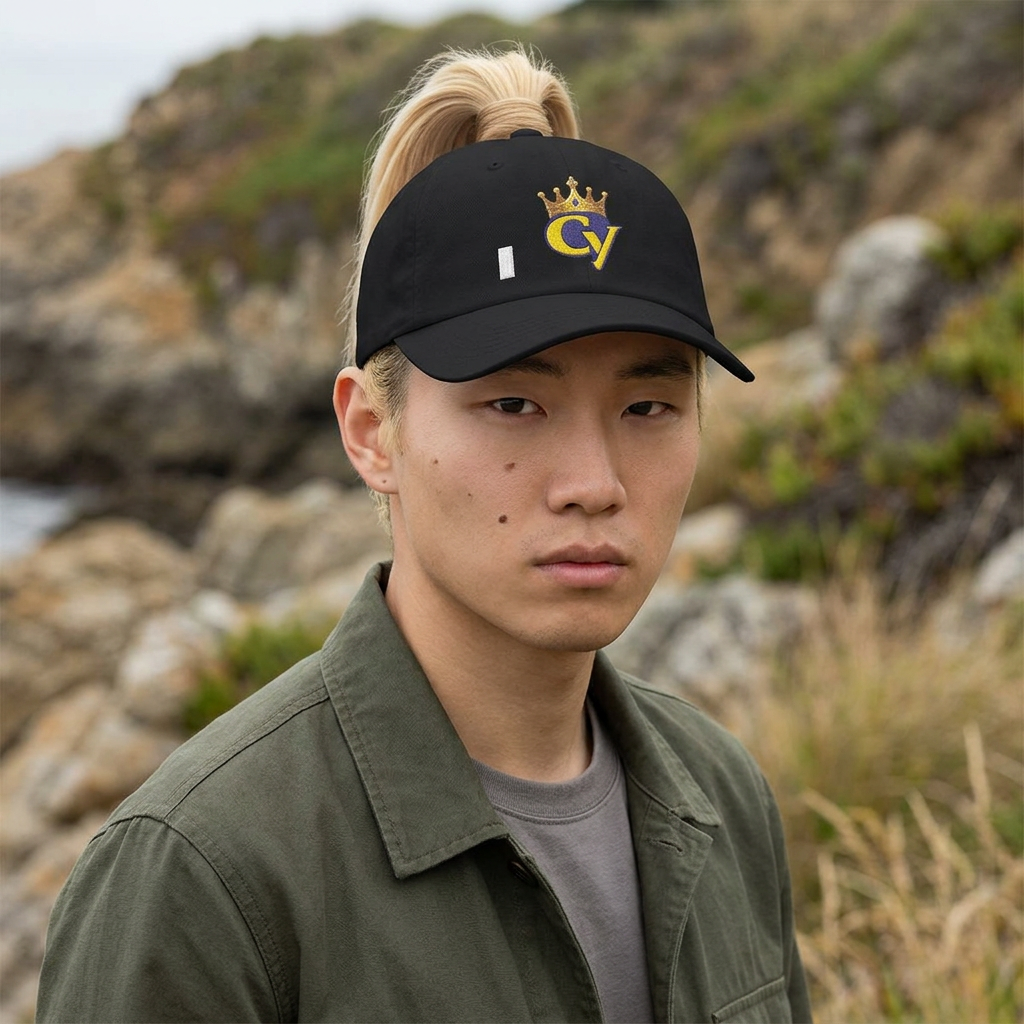 Person wearing a black cap with a logo in an outdoor setting