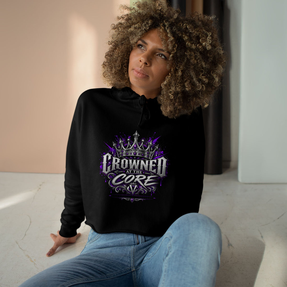 Core Vitality Crowned at The Core black hoodie with 'UNBOtherED' design sitting on a light-colored floor.