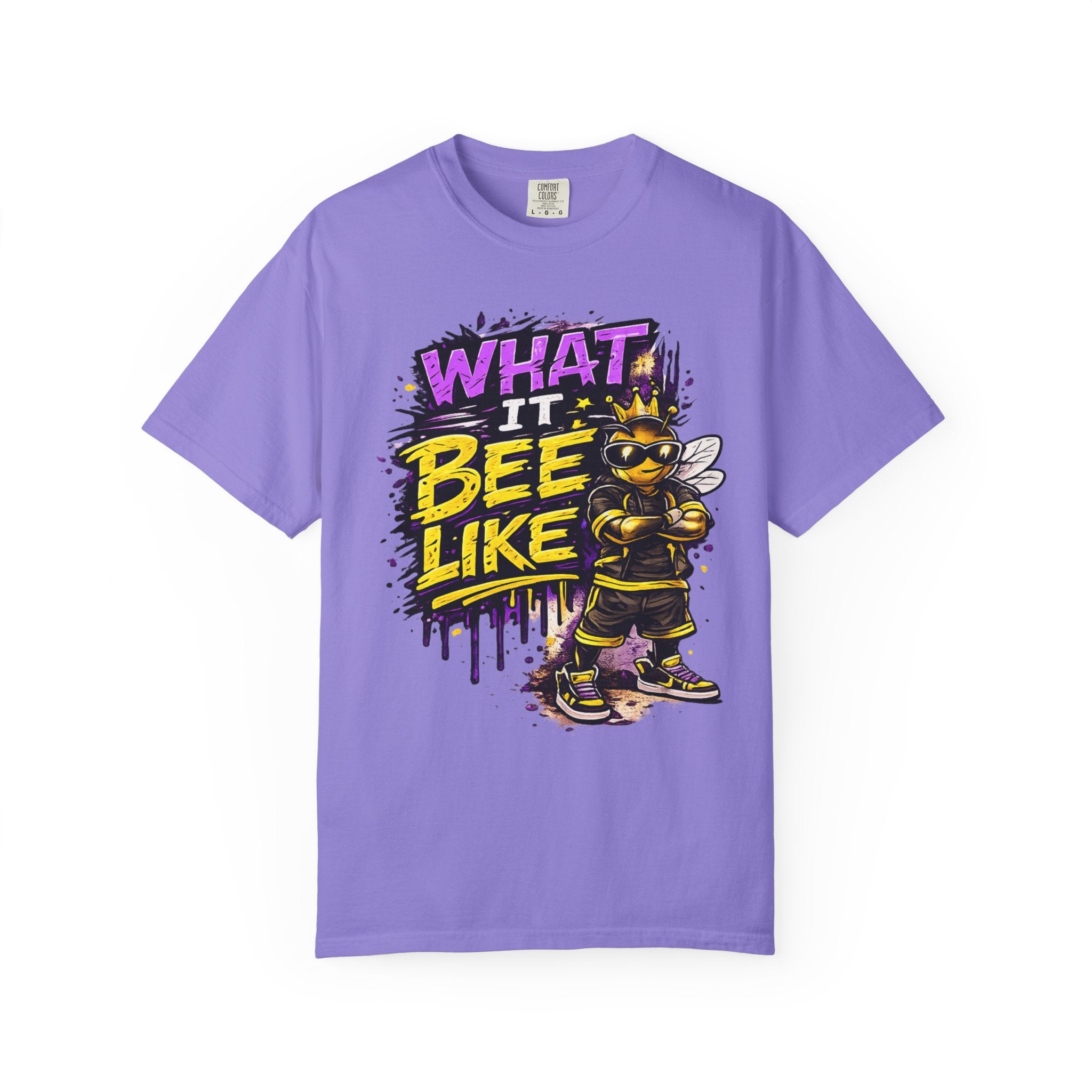 A purple short-sleeve crewneck t-shirt featuring a colorful graphic of a bee wearing sunglasses and a crown next to the text 'WHAT IT BEE LIKE' in yellow and purple.